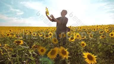日落时分，农夫手拿一瓶向日葵油。满族农耕塑料瓶油生活方式