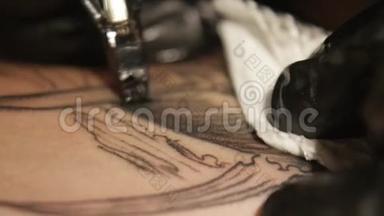 纹身艺术家在工作室做纹身，纹身在身体上。 近点