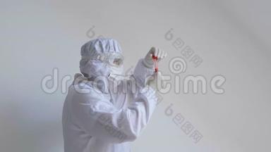 医生戴着<strong>流感</strong>面罩和防护手套，拿着一个带有冠状病毒血样的试管。 <strong>预防流感</strong>