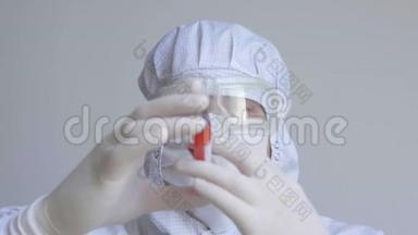 医生戴着流感面罩和防护手套，拿着一个带有冠状病毒血样的试管。 预防流感