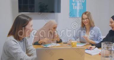 四个自信、开朗、多元化的同事办公室女头巾讨论商业计划笑笑笑