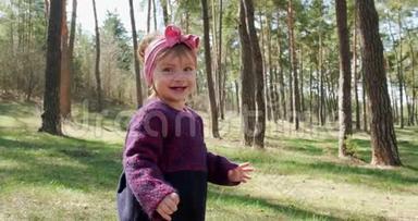 快乐的小女孩在针叶林中的树林中绿草如茵地散步。 与社会隔绝的健康儿童娱乐活动