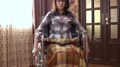 坐轮椅的年轻女子。 女孩坐轮椅在房子周围<strong>走动</strong>。 女孩正在接近摄像机。
