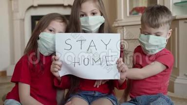 家庭呆在家里的概念。 三名戴<strong>口罩</strong>的<strong>儿童</strong>在家中等候病毒保护并照顾他们