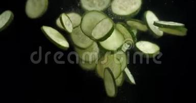 新鲜黄瓜片落入水中，有气泡。