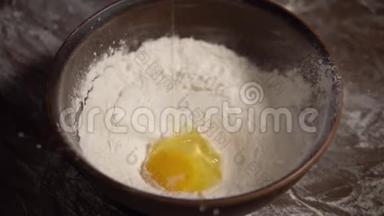 鸡蛋在碗中缓慢地落入面粉中