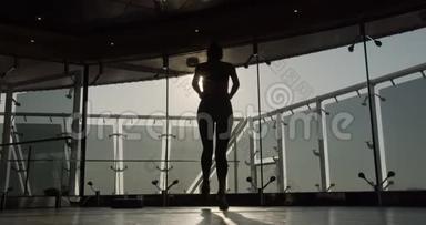 漂亮自信的健身女孩穿着运动健身服正在做热身运动。