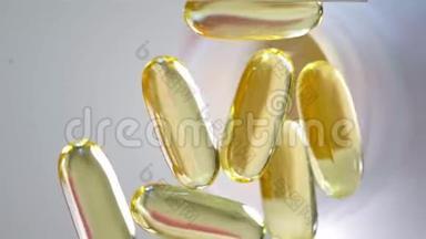 欧米茄3黄金鱼油胶囊，旋转背景。 在白色背景上分离的胶囊和许多其他胶囊上