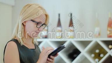 一位戴眼镜的年轻女子的肖像，在咖啡馆里等待她的点菜时使用智能手机