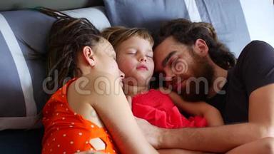 有孩子睡在床上的家人。 白天和全家一起睡觉