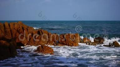 海浪拍打着海水中的大岩石，海水清澈