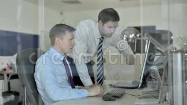 成熟的商业人士在使用办公电脑时，与两位嘉宾一同庆祝