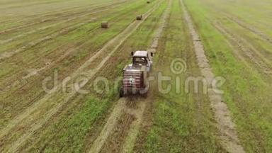 一种带有圆形打包机的拖拉机的鸟瞰图，它可以在收获的土地上制造成捆的稻草，这是一种农业综合企业的概念