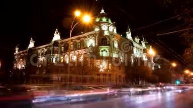 时光流逝。 罗斯托夫市的行政部门在夜间，从汽车前灯照到美丽的建筑灯光