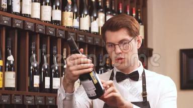 优雅的葡萄酒销售商在一家葡萄酒商店里拿着一瓶葡萄酒和阅读标签