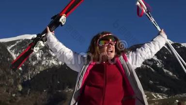 穿着滑雪服、戴着镜子眼镜、手里拿着滑雪板和滑雪杆的活跃女孩尖叫着投掷和胜利