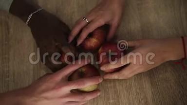 4个<strong>不</strong>同种族的人从木桌上摘漂亮的红苹果