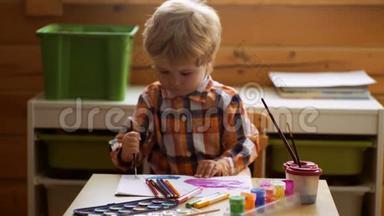 幼儿`绘画工具.. 油漆调色板，刷子和纸。 儿童绘画。 学龄前儿童玩具