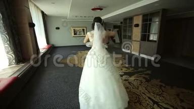 新婚快乐的新婚夫妇在一个房间里跳华尔兹，在一个酒店里有一个美丽的内部。