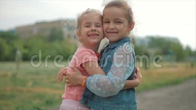 两个微笑、卷曲、可爱的姐妹紧紧地拥抱着对方。 快乐童年，积极情绪，<strong>真情</strong>实感..