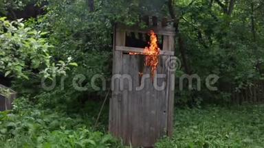 一个年轻人从着火的乡村厕所里出来，试图用<strong>灭火</strong>器<strong>灭火</strong>。 一片燃烧