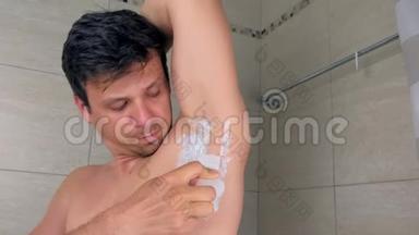 男人剃须腋窝<strong>脱毛膏</strong>使用刮刀在浴室在家里。