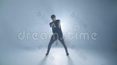 时髦的现代风格嘻哈舞者在蓝色工作室背景下展示他的舞蹈。