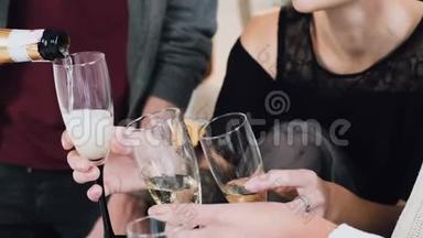 一群混血朋友用香槟庆祝新年或圣诞聚会。 人们<strong>把酒</strong>杯放在