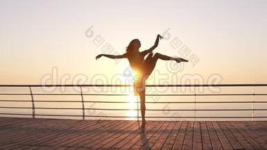 迷人的芭蕾舞演员练习伸展。做经典的芭蕾舞动作。黑衣长发少女