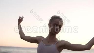 一个优雅的芭蕾舞演员在外面跳舞，背景是海。 白人芭蕾舞演员