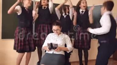 穿校服的学生正站在一位坐在椅子上打电话的老师旁边。 概念