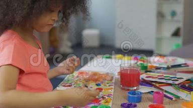 小非洲裔美国女孩在幼儿园练习绘画，休闲活动