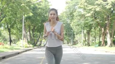 年轻迷人的女人在绿色城市公园跑步锻炼户外健身跟踪<strong>可穿戴</strong>技术。