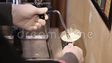 工作中的酒保准备热牛奶泡沫，制作浓缩咖啡和蒸汽牛奶