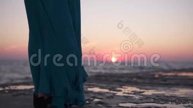 一个穿着连衣裙的孤独女孩在码头上的海面上<strong>遇见</strong>了黎明.. 这件衣服植根于太阳的背景