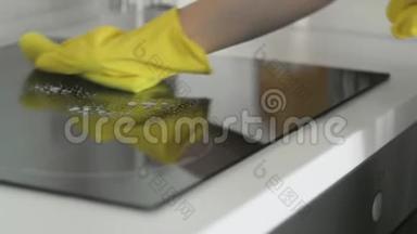 用除脂剂喷雾剂和黄色抹布<strong>清洗</strong>厨房的烹饪面板，由一位戴黄色橡胶手套的女士<strong>清洗</strong>。