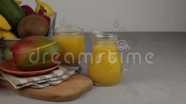 果篮和一杯果汁。新鲜<strong>芒果汁</strong>，橙汁。桌子上的水果篮。新鲜水果和果汁