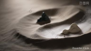 <strong>山</strong>丘形状的石头在太极图案的沙子上