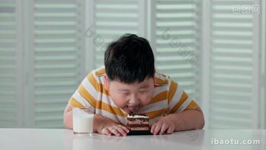 快乐的小胖男孩喝牛奶吃<strong>蛋糕</strong>