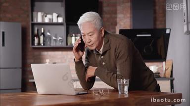 老年人一边使用电脑一边打电话