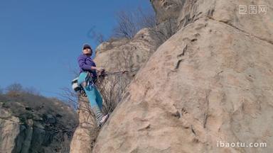 青年女人在<strong>悬崖</strong>峭壁上攀岩