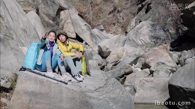 青年登山者伴侣坐在石头上休息