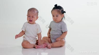 两个可爱宝宝坐在地上<strong>玩耍</strong>