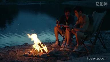 年轻人夜晚在野外篝火露营喝酒天空场景拍摄