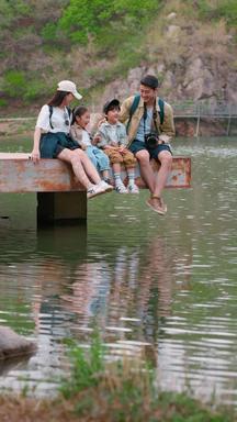 快乐家庭坐在湖边玩耍