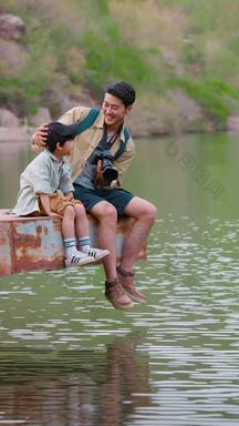 快乐父子坐在湖边玩耍相伴视频
