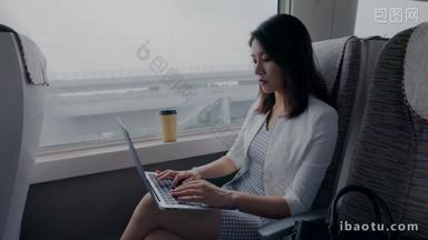 年轻商务<strong>女</strong>士在高铁上使用笔记本电脑