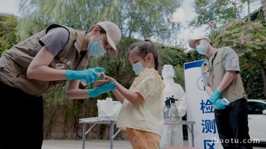志愿者给小女孩消毒洗手液25岁到29岁镜头