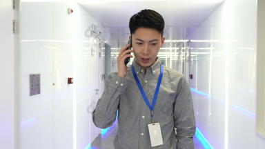 年轻技术员在走廊里打电话线电通信装置