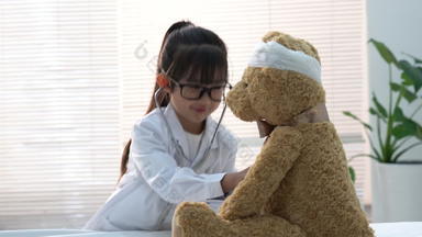 装扮成医生<strong>的</strong>小女孩给玩具小熊看病